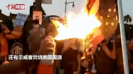 　　图为示威者焚烧美国国旗。图片来源：中新视频截图。