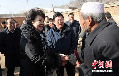 甘肃省副省长夏红民（中）陪同国侨办主任裘援平在甘肃积石山看望贫困户。