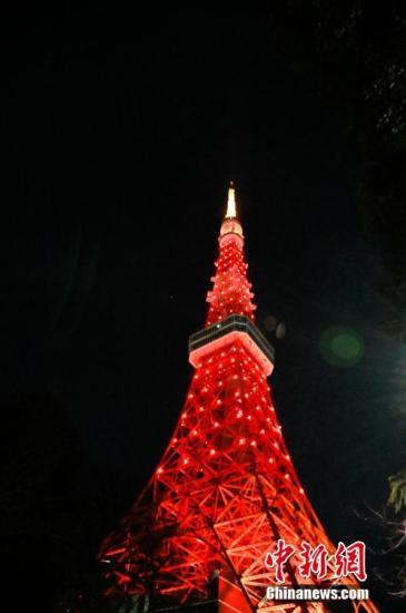 当地时间2月18日，东京塔点亮中国红，为中日两国携手抗击疫情加油打气。中新社记者