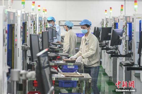 　　资料图：2月20日，位于广州南沙区的安捷利(番禺)电子实业有限公司内，复工人员戴着口罩在生产车间有序工作。中新社记者